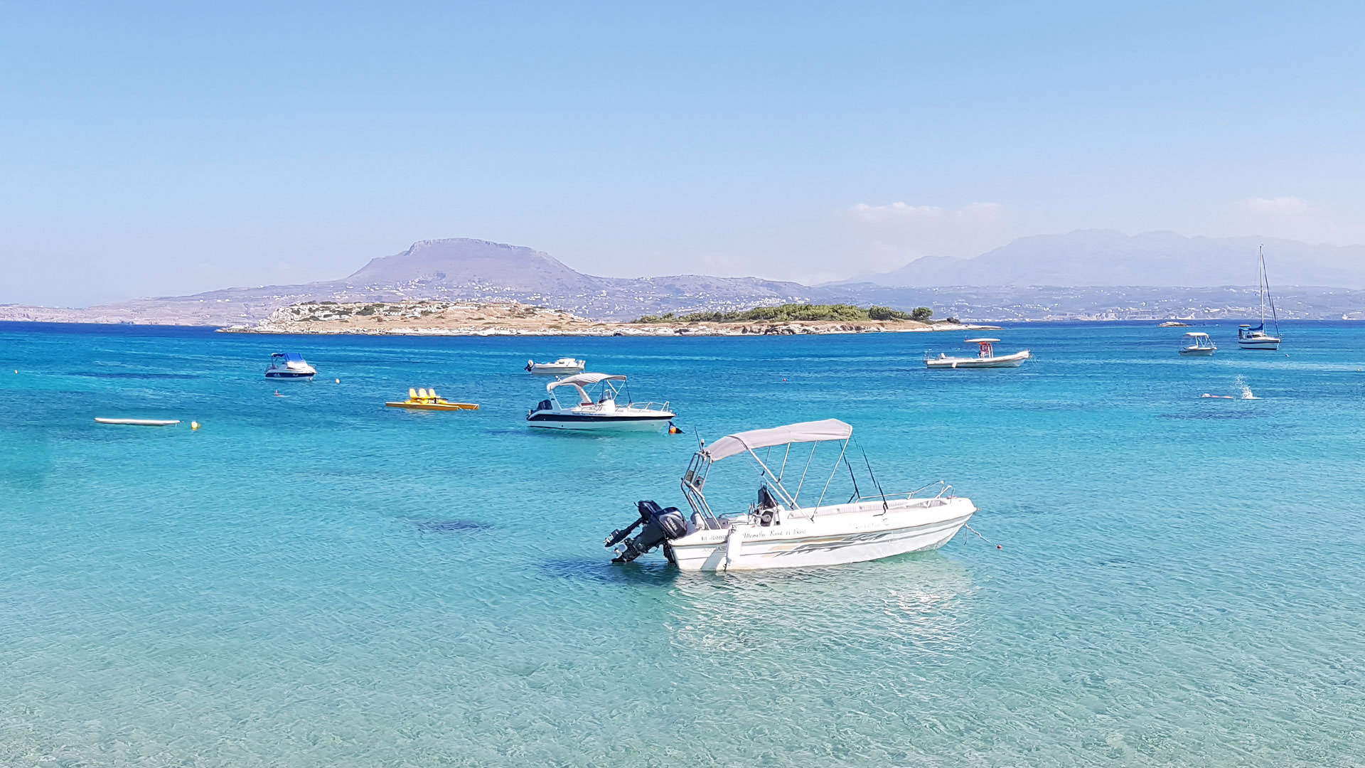 Marathi Beach Chania Crete with calm turquoise water and boats
